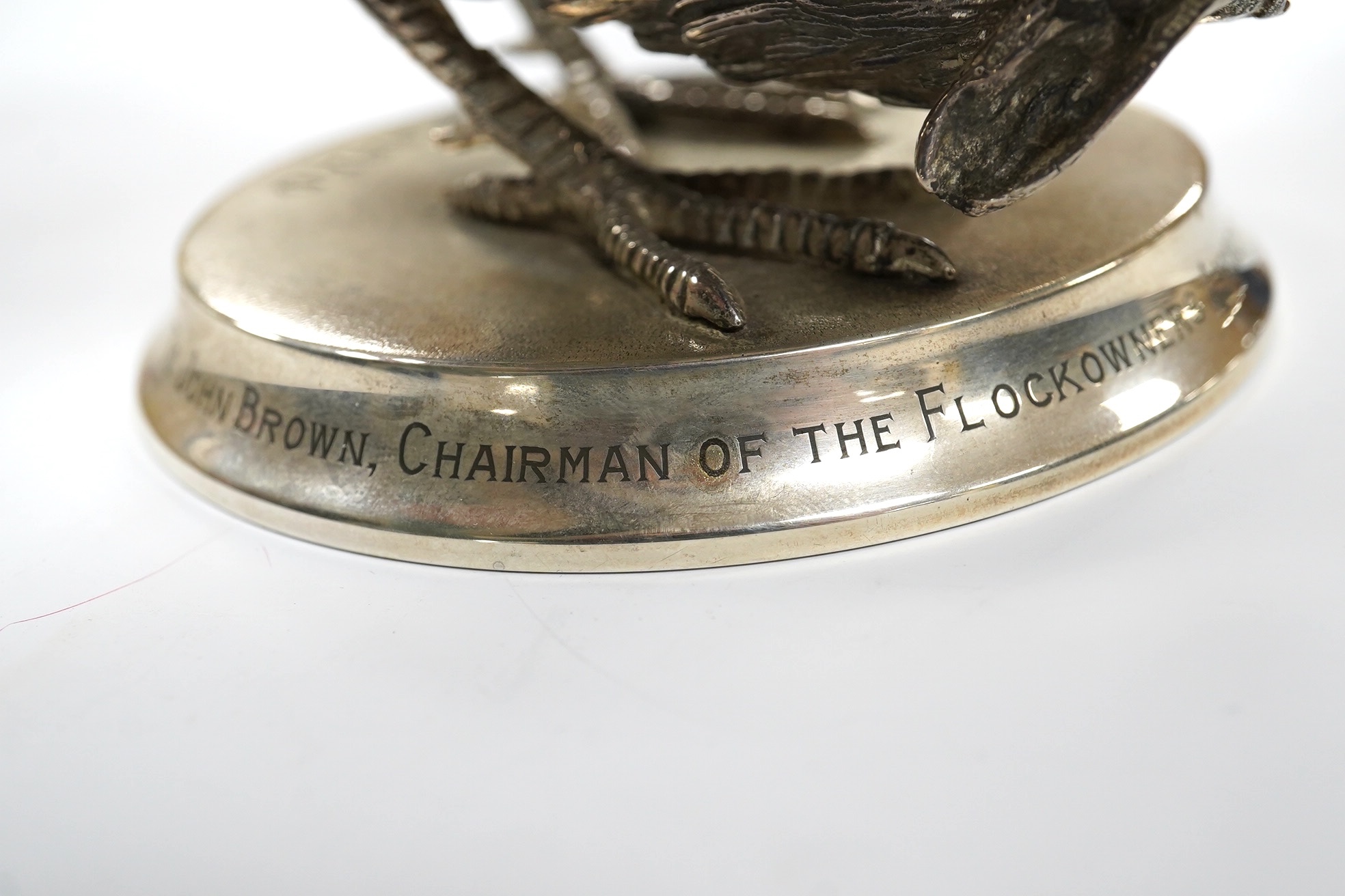 An Elizabeth II silver presentation cockerel, on a circular base with engraved inscription, by Garrard & Co Ltd, London, 1953, overall height 14cm, weighted. Condition - fair to good